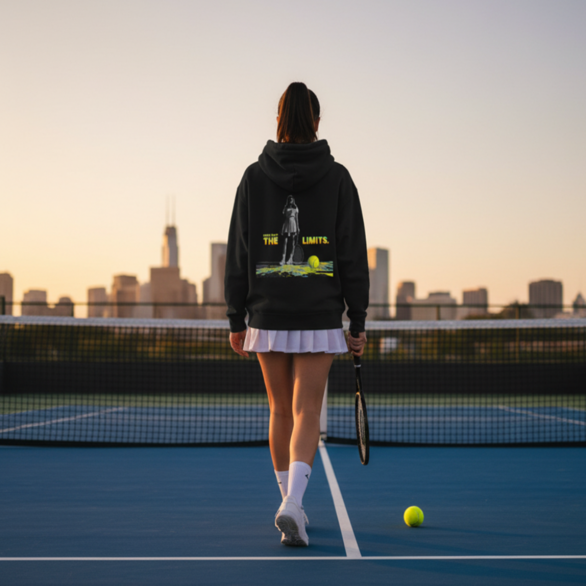 Person on a tennis court with a city skyline in the background
